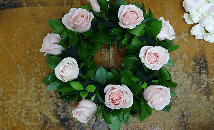 Add your focal flowers into the arrangement. Here, we are using Rose Sweet Avalanche. Before placing the stems into the arrangement, cut the stems short and remove the guard petals (optional).
