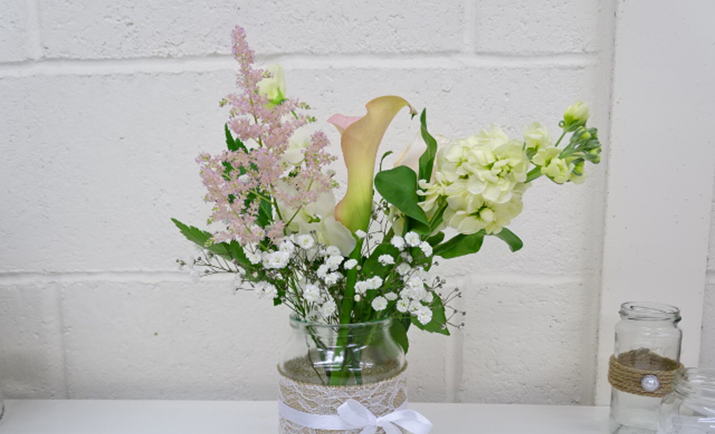 Continue to add the flowers to the arrangement using the gypsophila as a frame. Cut and place the flowers in an aesthetically pleasing way.
