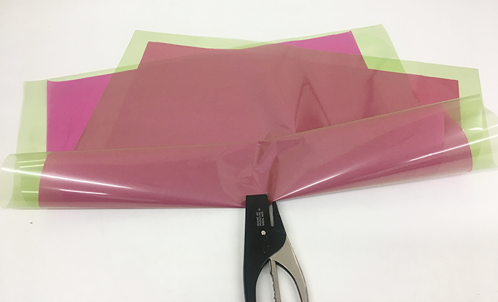 Lie the tissue paper on the cellophane and fold in half at an angle so you can see all four points (with the tissue on the inner). 
                                                